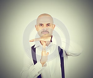 Bald man showing time out hands gesture