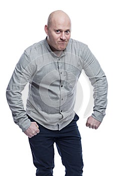 A bald man shows his muscles funny. Guy in a gray shirt. Positivity and humor. Isolated on a white background. Vertical