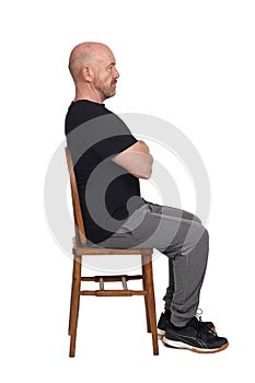 Bald man with sportswear sitting on white background