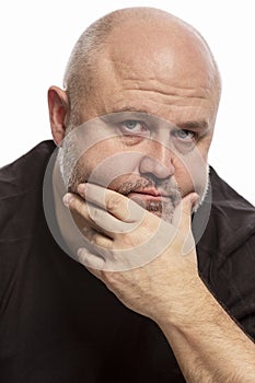 A bald man thinks covered his face with his hands