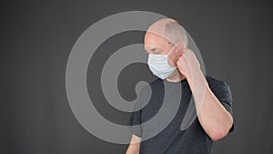 Bald man wearing protective facial mask for health care in epidemic. Adult man taking off protective mask from face in