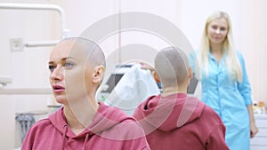 Bald woman at a consultation with a doctor in a clinic. The concept of trichology, oncology, alopecia.