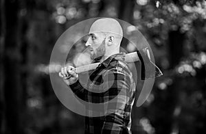 Bald woodsman worker. live on rancho. concept of masculinity. bearded hipster cut tree. man checkered shirt use axe