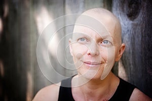 Balding cancer patient outside looking happy