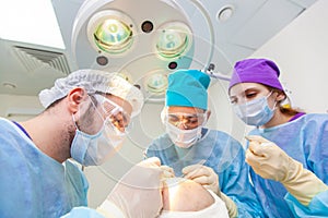 Baldness treatment. Hair transplant. Surgeons in the operating room carry out hair transplant surgery. Surgical