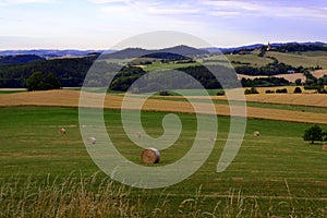 Bale of hays on meadow field on hillside