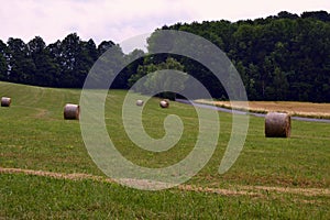 Bale of hays on meadow field on hillside