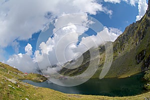 Balea lake and Balea Hotel in spring time with clouds