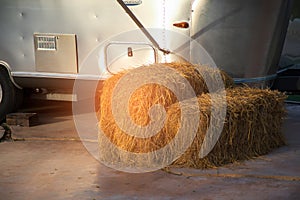 bales of hay on the floor beside tractor