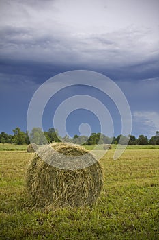 Bales of hay under stormy sky