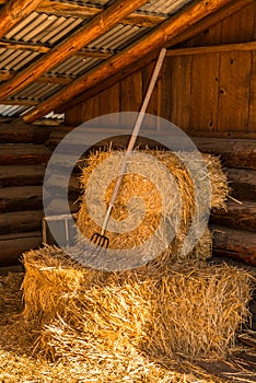 Bales of Straw Hay with Pitchfork in Barn