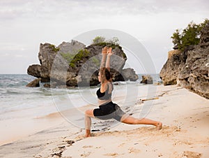 Bali beach yoga. Caucasian woman practicing Virabhadrasana I, Warrior I Pose. Strong body. Healthy lifestyle. Self-care concept.