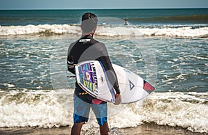 Male surfer on a beach preparing to catch some waves