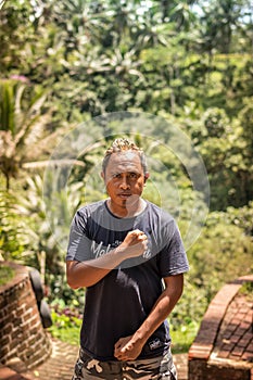 BALI, INDONESIA - DECEMBER 5, 2017: Closeup portrait of asian balinese indonesian man in the jungle of Bali island.