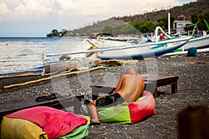 Tourist relaxing in typical small Black Sand Beach cafe on Bali