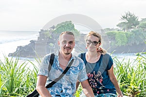 BALI, INDONESIA - MAY 4, 2017: Woman and her son on a background of Pura Tanah lot temple, Bali island, Indonesia.