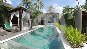 Bali, Indonesia, November, 2016: A view of the territory of the tropical resort with the pool palm trees and chaise