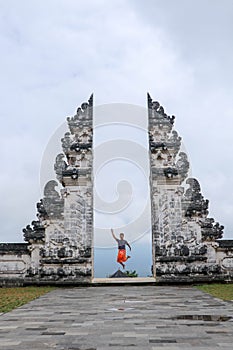 Bali, Indonesia. Young taveler man jumping with energy and happiness in the gate of heaven. Lempuyang temple