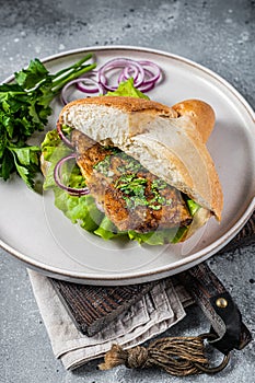 Balik Ekmek Turkish fish sandwich with grilled mackerel fillet in a bun. Gray background. Top view