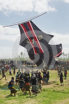 Balinese men try to catch big traditional kite