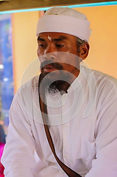 Balinese priest in traditional clothes performing The Melaspas Ceremony, often called the house blessing ceremony