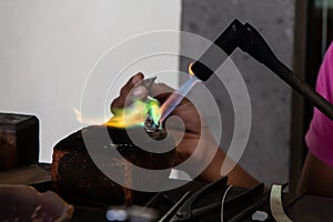 Balinese woman handcrafting a silver ring with a blow torch, Bali, Indonesia