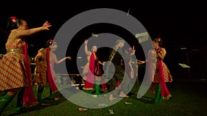 Balinese women celebrate the ritual ceremony with dancing while a man wasting money to the sky between the dancer on the stage