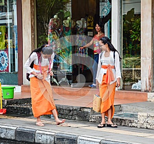 Balinese women walking on street in Bali, Indonesia