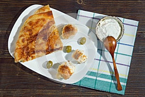 Balkan cuisine. Burek with cheese. Kajmak in small dish. Flat lay. Dark rustic background photo