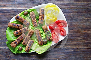 Balkan cuisine. Cevapi - grilled dish of minced meat on rustic table. Copy space