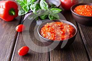 Balkan sauce ajvar and ingredients for its preparation on a wooden table. Serbian traditional food