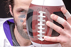 Ball for American football in front of footballer face