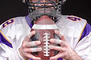 Ball for American football in front of footballer face