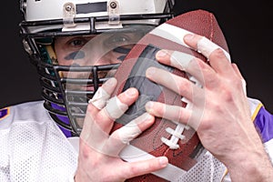 Ball for American football in front of footballer face