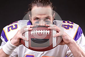 Ball for American football in front of footballer face