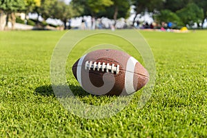 ball for American football on grass field. Close up view with out of focus background.