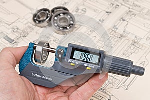 Ball bearings measurement. Micrometer screw gauge in human hand