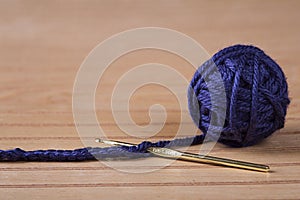 Ball of blue yarn with crochet needle