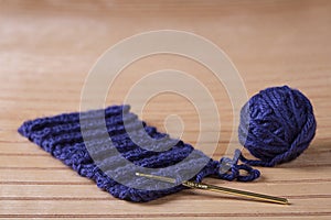 Ball of blue yarn with crochet needle