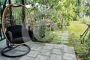 Ball Chair in the garden. Empty wicker cradle with copy space