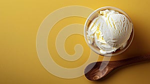 A ball of creamy ice cream and a wooden spoon on a yellow background