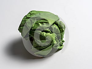 A ball of crumpled green paper on a light background