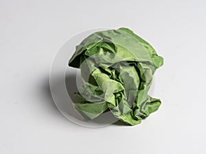 A ball of crumpled green paper on a light background