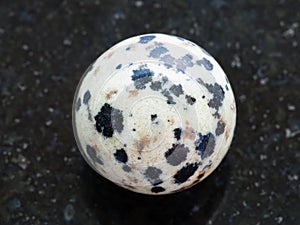 ball from Dalmatian Jasper gemstone on dark photo
