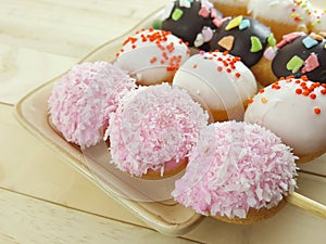 Ball donuts scatter over of colorful sugar.