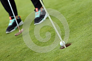 The ball falling in golf hole