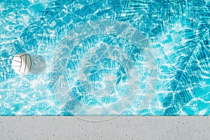 Pool float, ring floating in a refreshing blue swimming pool with palm tree leaf shadows in water