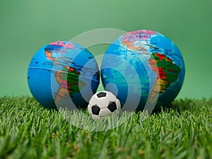 Ball between globes on a green background