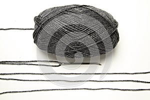 Ball of gray wool with strips of wool on old needle