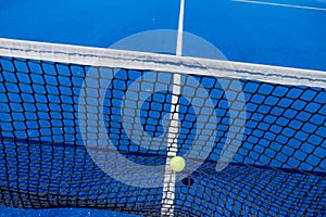 ball hitting the net of a paddle tennis court